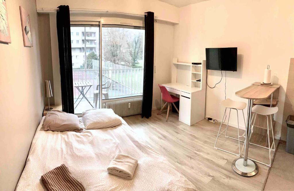 - une chambre avec un lit, un bureau et une fenêtre dans l'établissement Studio LEON, à Chambéry