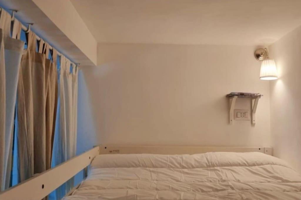 トリノにあるIncantevole appartamento a Torino!の小さなベッドルーム(ベッド1台、カーテン付)