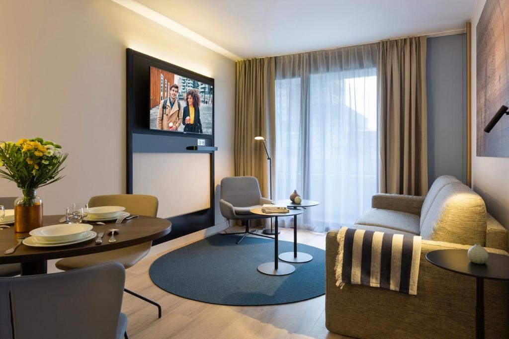 庫爾布瓦的住宿－馨樂庭巴黎德芬斯酒店，客厅配有沙发和桌子