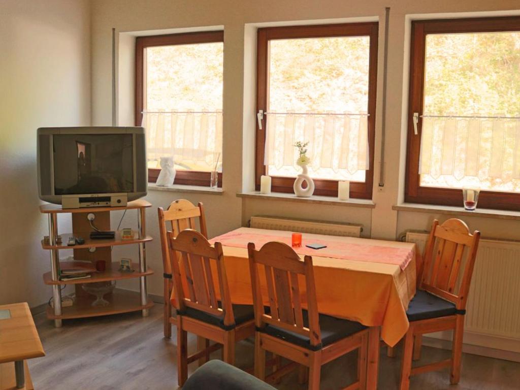 een eetkamer met een tafel en stoelen en een televisie bij Zur Dorfschänke in Medebach