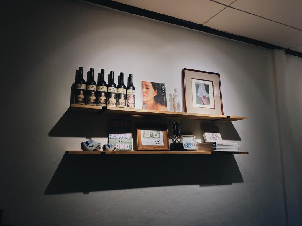 a shelf with bottles of wine on a wall at Ceraclay Home in Nan