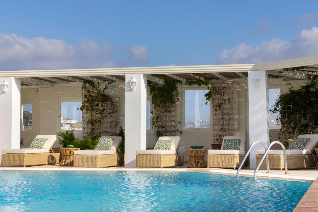 a pool with chaise lounge chairs and a swimming pool at Dorion Hotel in Ornos