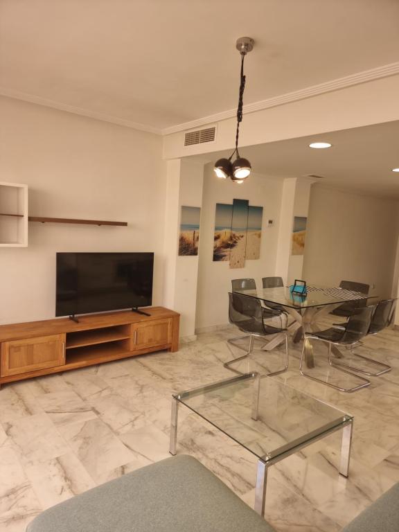 sala de estar con mesa de cristal y TV de pantalla plana en Aleksandra Apartament Sant Pere en El Campello