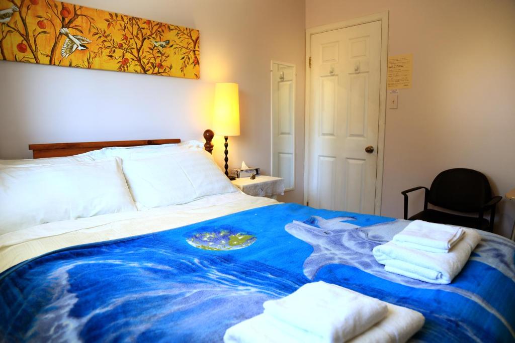 um quarto com uma cama grande e toalhas em Jenny Guest House em Yellowknife