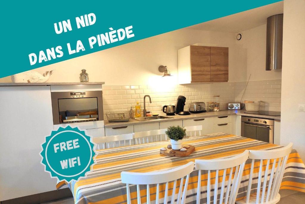 uma cozinha com uma mesa e cadeiras em Un Nid dans la Pinède em Lacanau