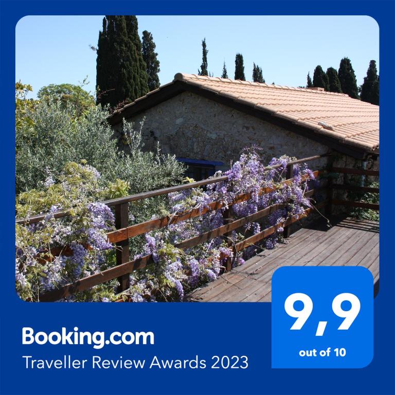 a house with purple flowers on a fence at Mercouri stone cottage in Korakokhórion