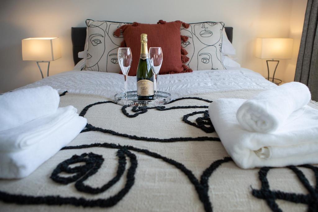 łóżko z 2 kieliszkami i butelką szampana w obiekcie Dragonfly House w mieście Maidenhead