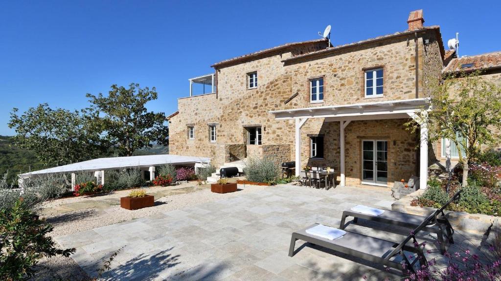 a stone building with a bench in front of it at Caciaia in Roccalbegna