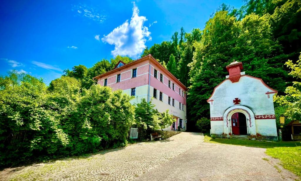 a pink and white building next to a road at HARABURDI® Recyclart Hotel in Kostelec nad Orlicí