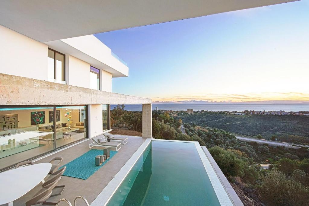 ein Haus mit einem Pool und Meerblick in der Unterkunft Luxury Villa Tomillo in Marbella