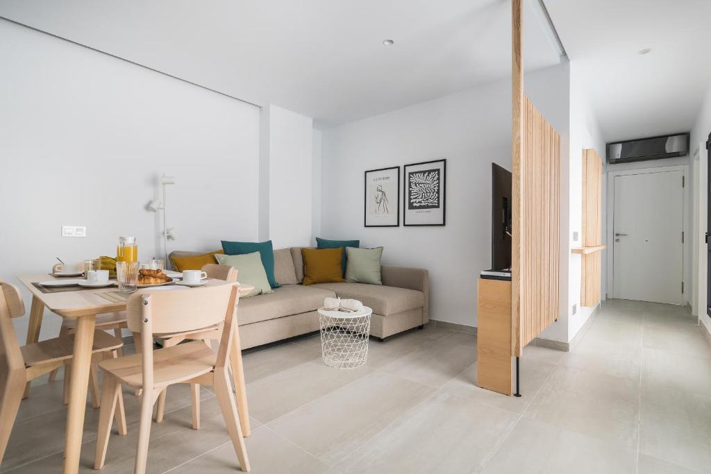 ein Wohnzimmer mit einem Sofa und einem Tisch in der Unterkunft Home2Book Sweet&Comfy Apartment Las Canteras in Las Palmas de Gran Canaria