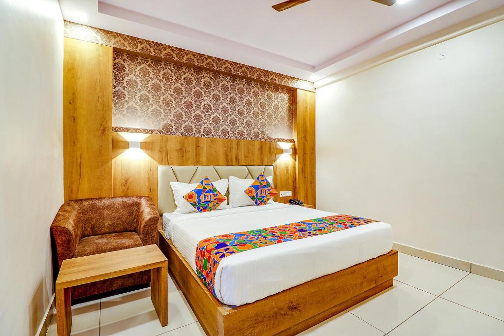 1 dormitorio con 1 cama grande y 1 silla en FabHotel Rotano Grand en Bangalore