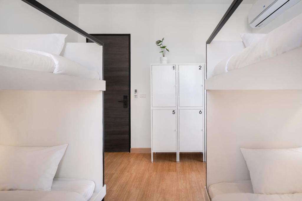 CASA BLANCA Dusit في Dusit: غرفة نوم مع سرير بطابقين أبيض ومرآة