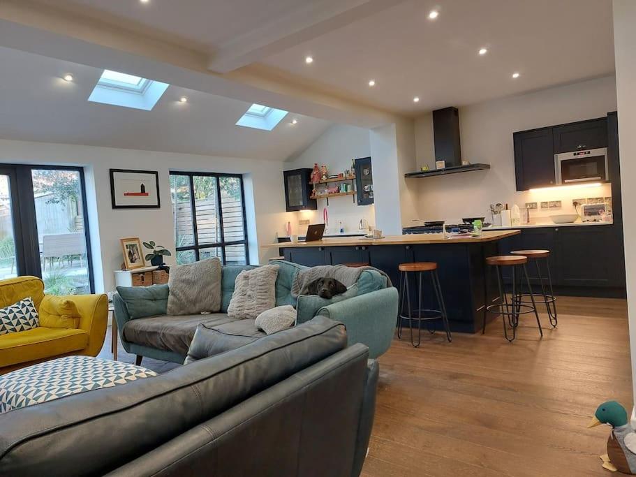 uma sala de estar com um sofá e uma cozinha em Beach House, with BBQ lodge and Hot Tub! em Bournemouth
