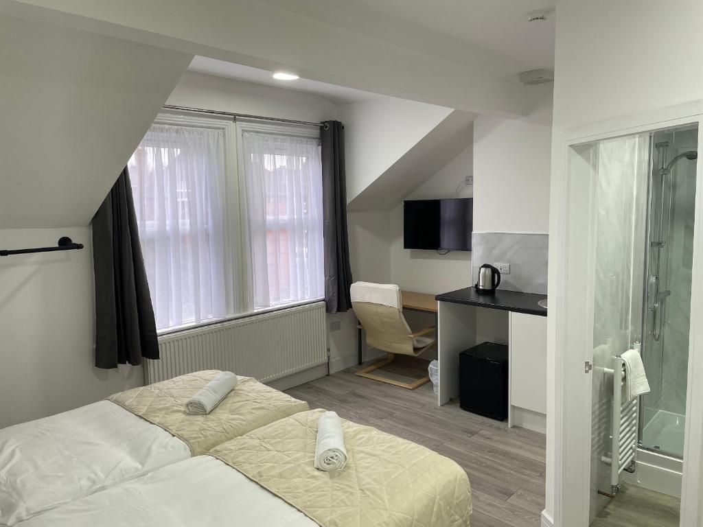 Pokój hotelowy z łóżkiem i biurkiem w obiekcie ISUITES w mieście Newcastle under Lyme