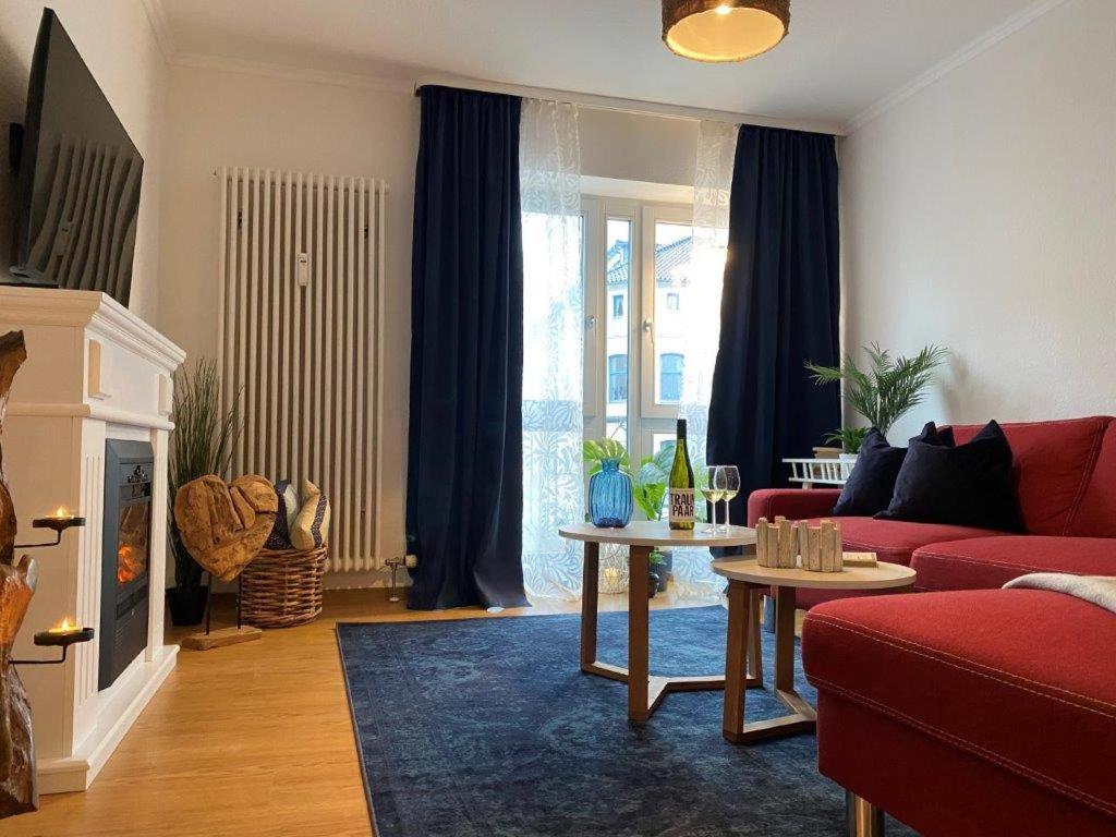 ein Wohnzimmer mit einem roten Sofa und einem Kamin in der Unterkunft Appartementanlage Ostseeblick in Kühlungsborn