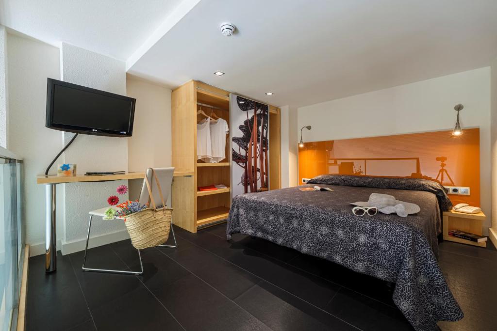 a bedroom with a bed and a flat screen tv at Estival Park Silmar in La Pineda