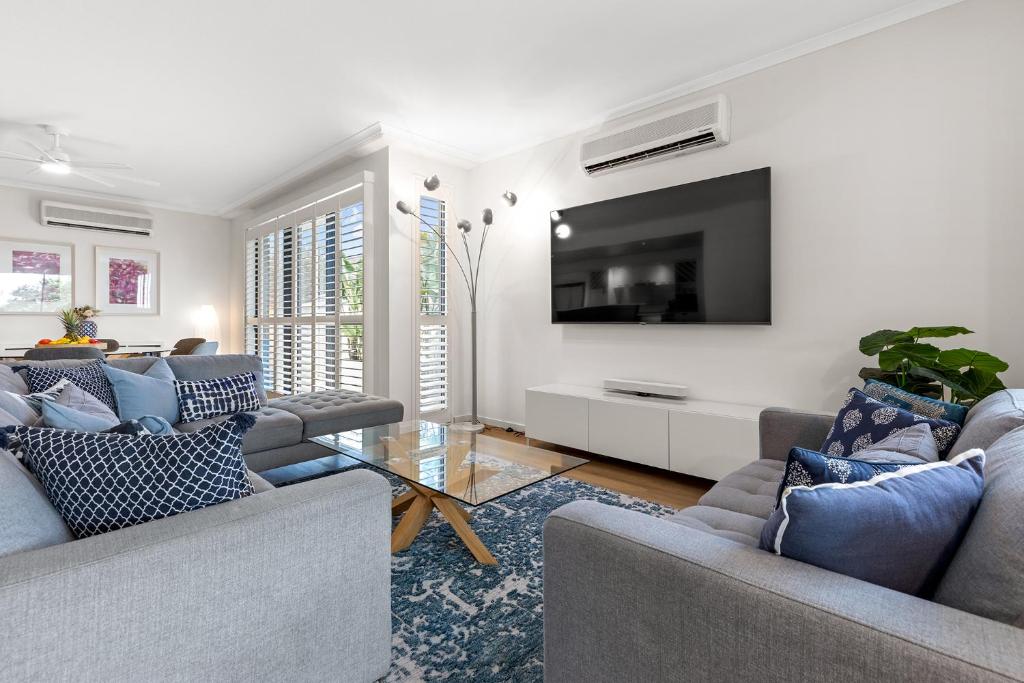 uma sala de estar com dois sofás e uma televisão em City oasis - 3 BR apt. on Maroochy river, pool, AC em Maroochydore