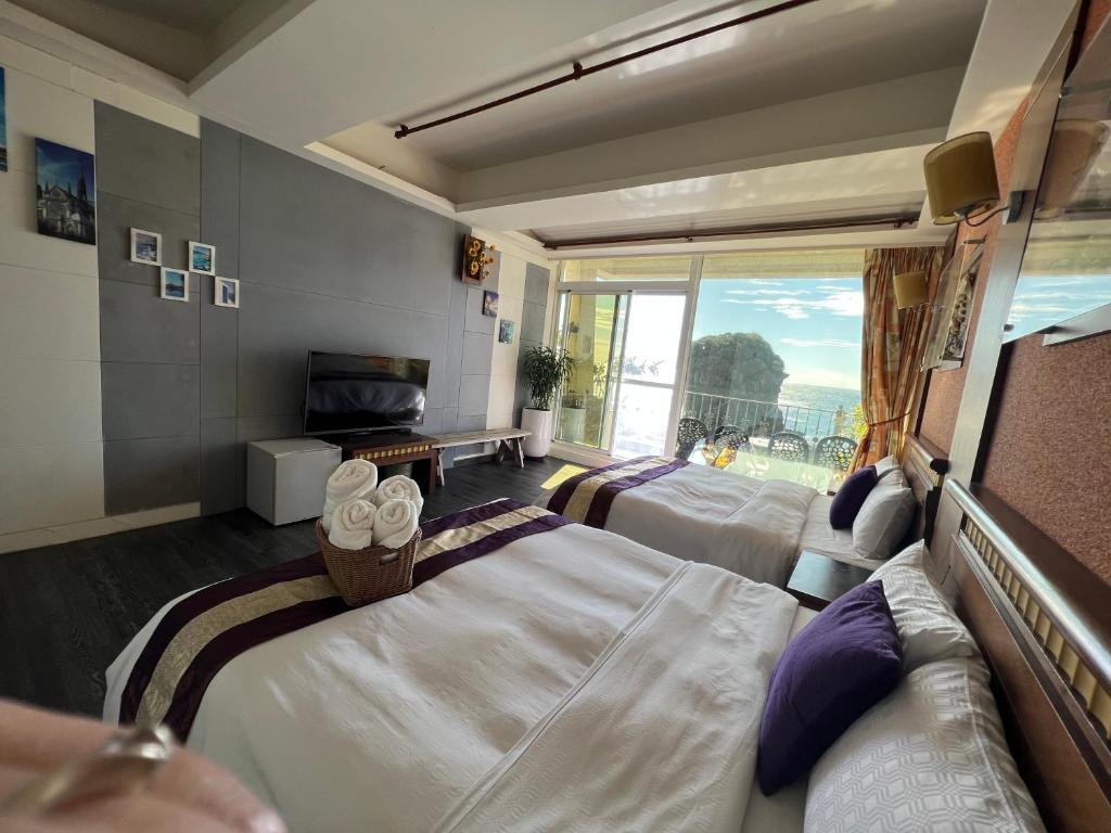 um quarto de hotel com duas camas e uma varanda em Ming Jun Homestay em Eluan