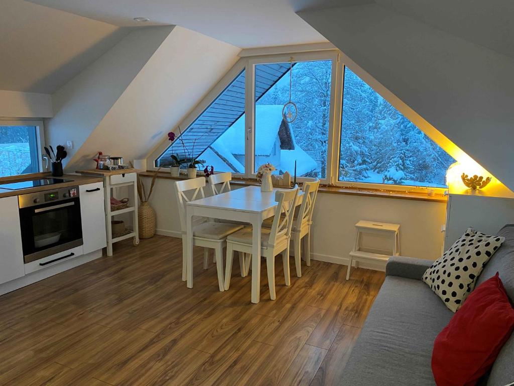 eine Küche und ein Wohnzimmer mit einem Tisch und Stühlen in der Unterkunft Apartment Židana marela - Attic with a View in Kranjska Gora