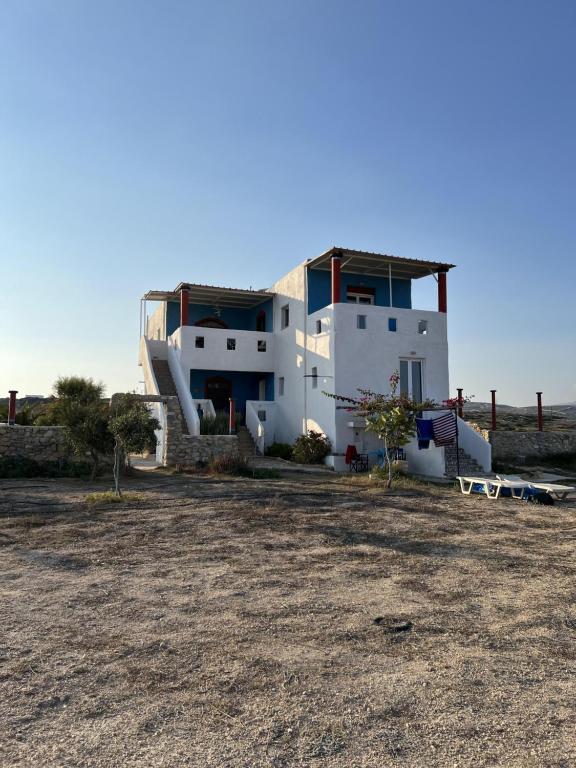 une grande maison blanche avec un escalier en face de celle-ci dans l'établissement Villa Hellas, à Afiartis