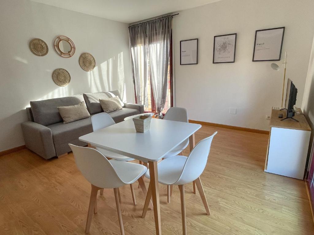 ein Wohnzimmer mit einem weißen Tisch und Stühlen in der Unterkunft AZ El Balcón de Luna in Saragossa