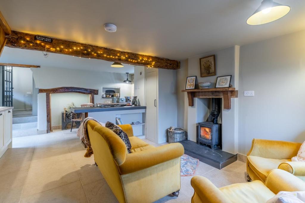 a living room with two couches and a fireplace at Cotswold Way Cottage in Stroud