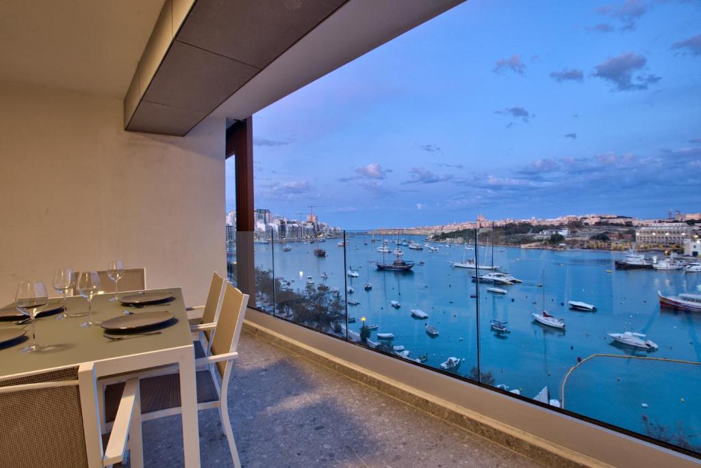 een eetkamer met een groot raam met uitzicht op een haven bij Sea Front Spacious Valletta Views Apartments in Sliema