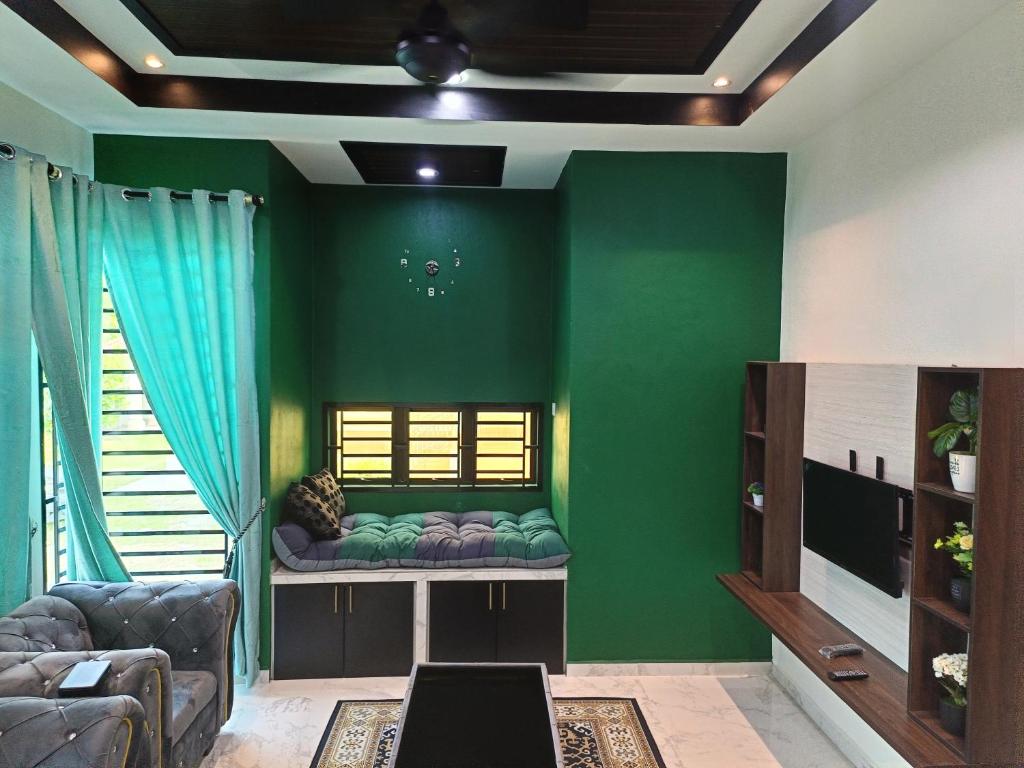 uma sala de estar com paredes verdes e um sofá em Qs Family Homestay Pasir Mas em Pasir Mas