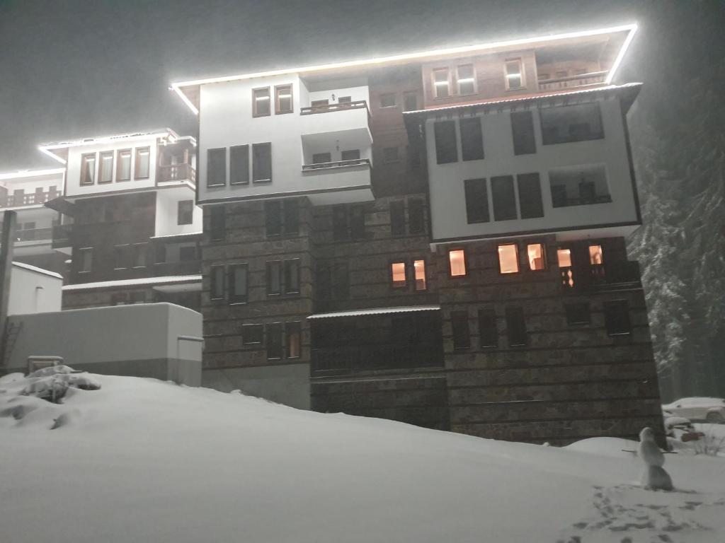 a building with snow in front of it at APARTMENT Darsi in Pamporovo