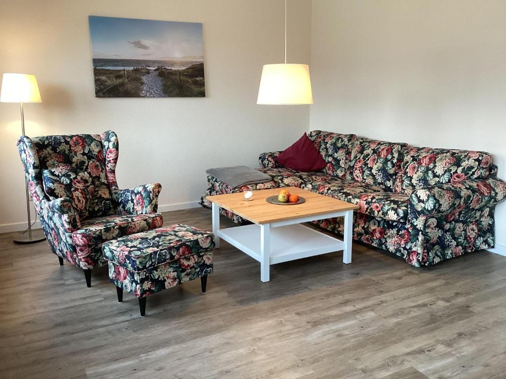 ein Wohnzimmer mit einem Sofa, einem Tisch und einem Stuhl in der Unterkunft Zur Alten Volksbank Wohnung 2 in Petersdorf auf Fehmarn