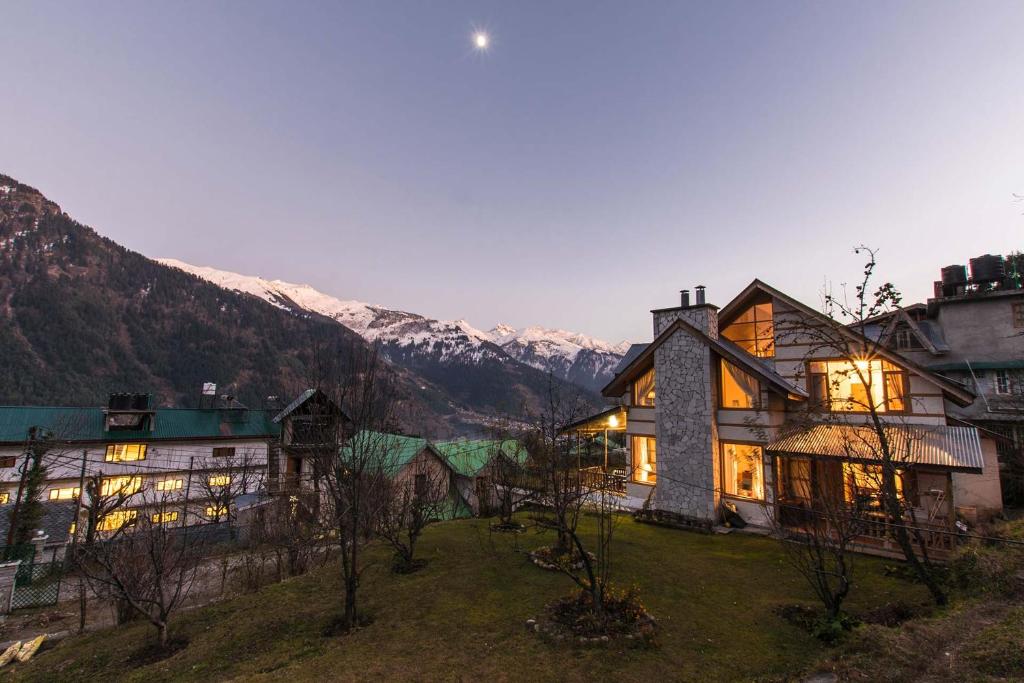 a large house with mountains in the background at StayVista at Jodhpur House - 3 BR Pet friendly Cozy villa in Manali in Manāli