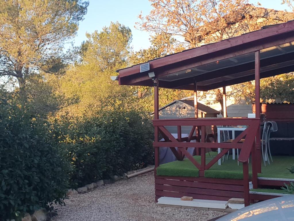 a gazebo with a bench in a yard at Mobilhome in Rocbaron