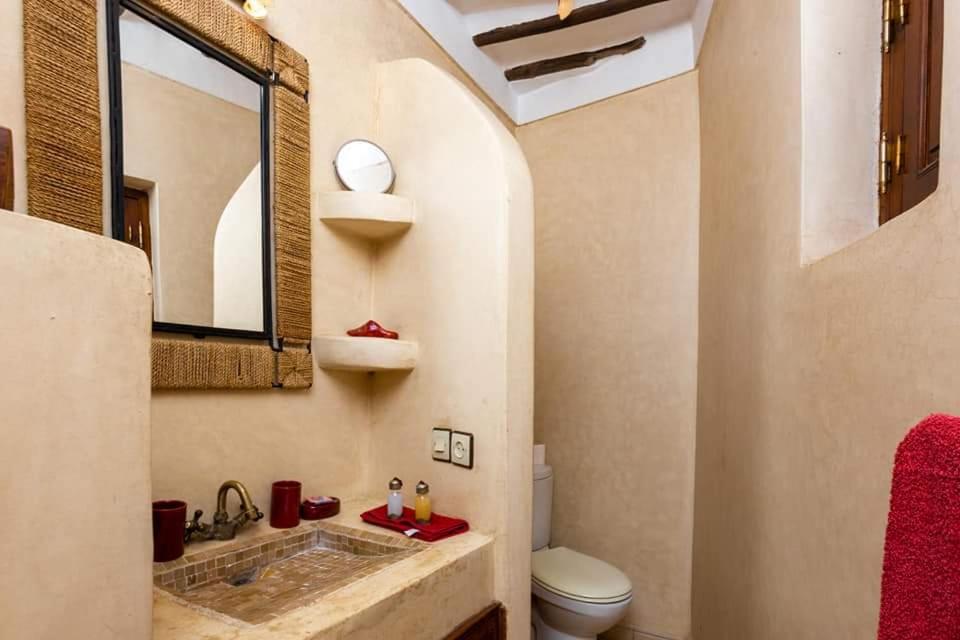 une salle de bain avec un lavabo et un miroir et des toilettes dans l'établissement Riad Aquarelle By GE, à Marrakech