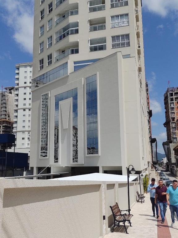 two men walking down a sidewalk in front of a building at Apto aconchegante e elegante Morretes itapema in Meia Praia