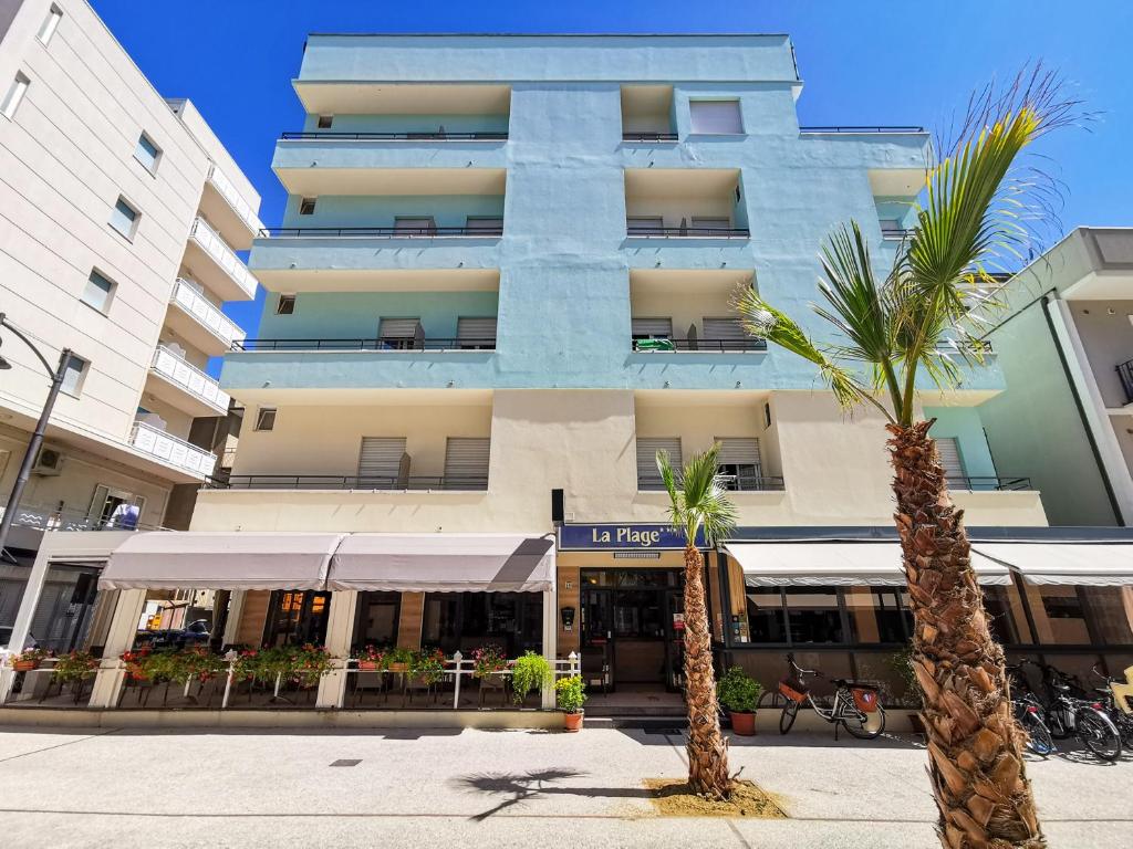 a building with a palm tree in front of it at Hotel La Plage in Cattolica