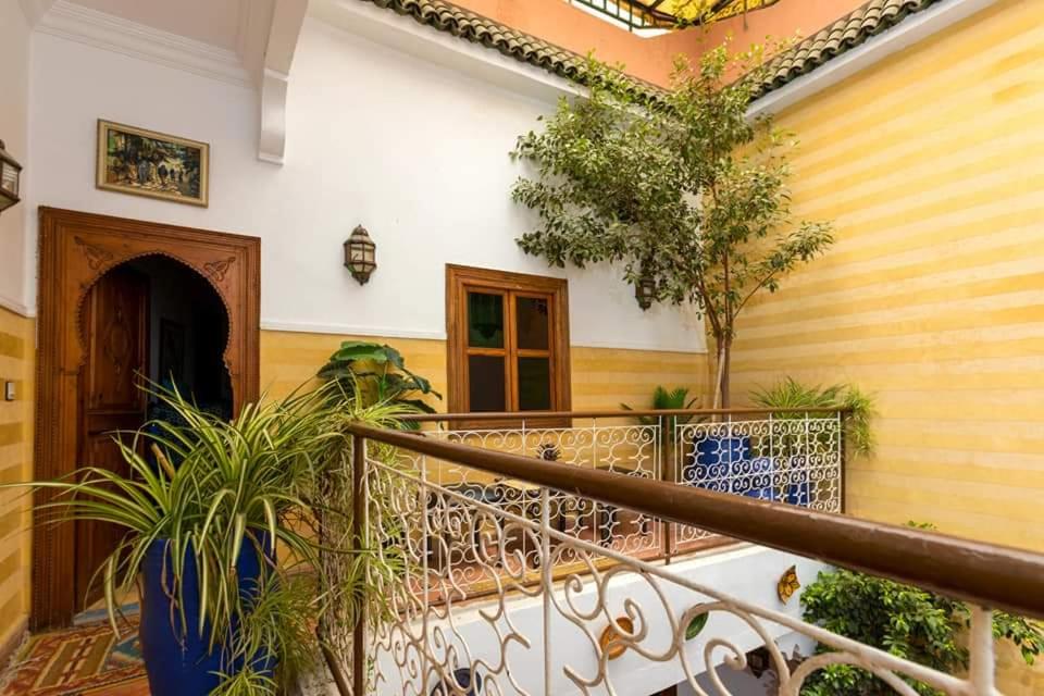 un balcon avec des arbres et des plantes dans un immeuble dans l'établissement Riad Aquarelle By GE, à Marrakech