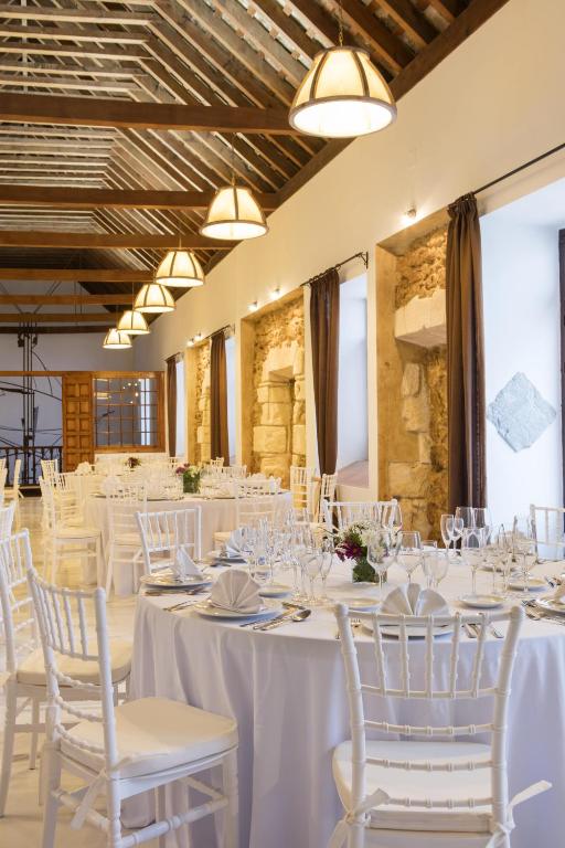 a set banquet hall with white tables and chairs at Hotel Tugasa Convento San Francisco in Vejer de la Frontera