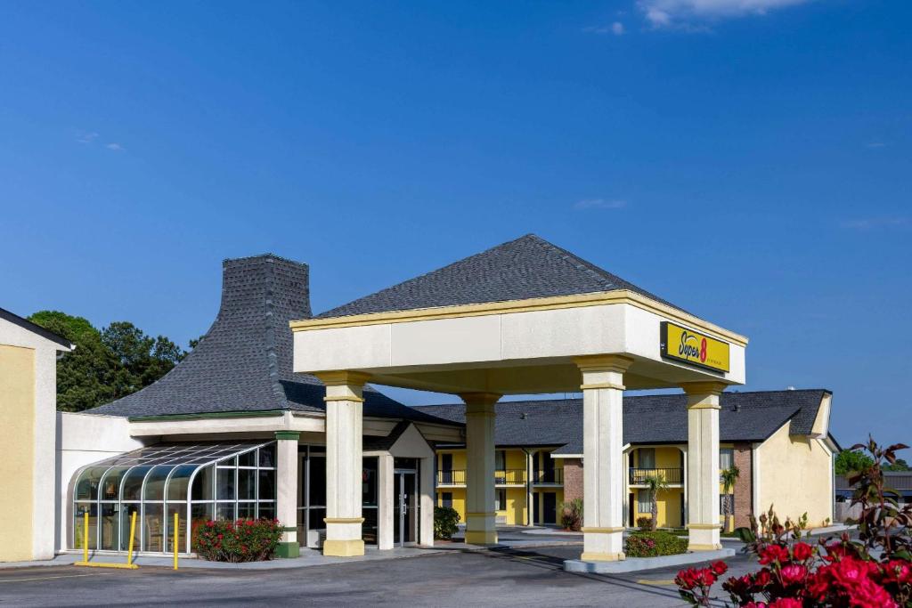 a hotel with a sign on the front of a building at Super 8 by Wyndham McDonough GA in McDonough