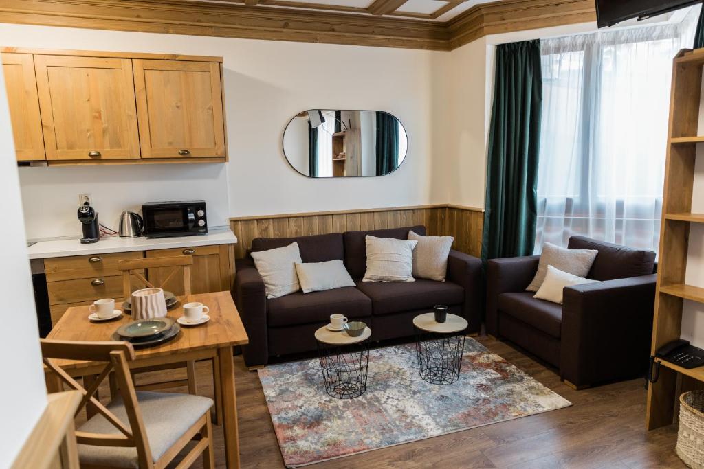 a living room with a couch and a table at Pirin Golf and Spa Cozy Studio in Bansko