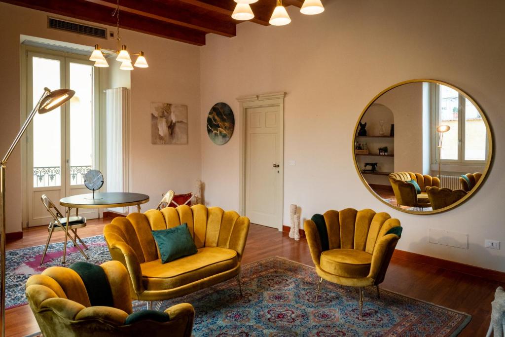 ein Wohnzimmer mit gelben Stühlen und einem Spiegel in der Unterkunft Borgo Antico B&b in Foggia