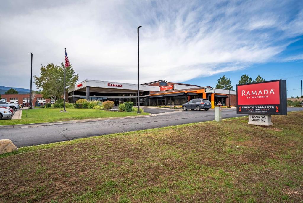 una señal frente a un edificio con un concesionario en Ramada by Wyndham Cedar City, en Cedar City