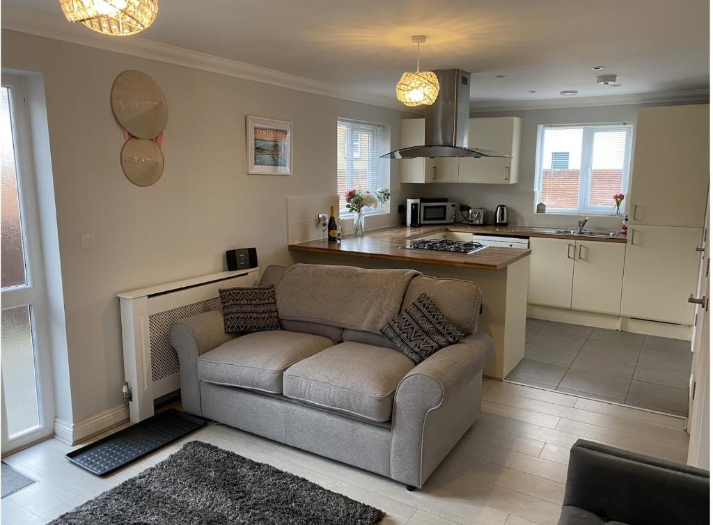 a living room with a couch and a kitchen at Modern House in Bournemouth town centre in Bournemouth