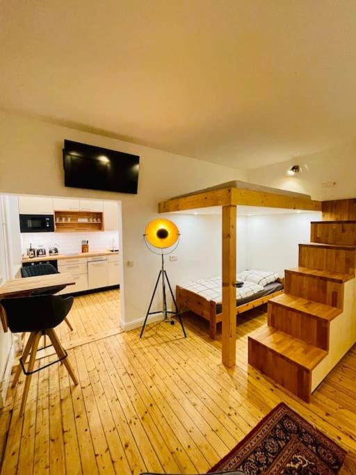 um quarto com uma escada e um quarto com uma mesa em Modernes Apartment nahe VW-Halle em Braunschweig