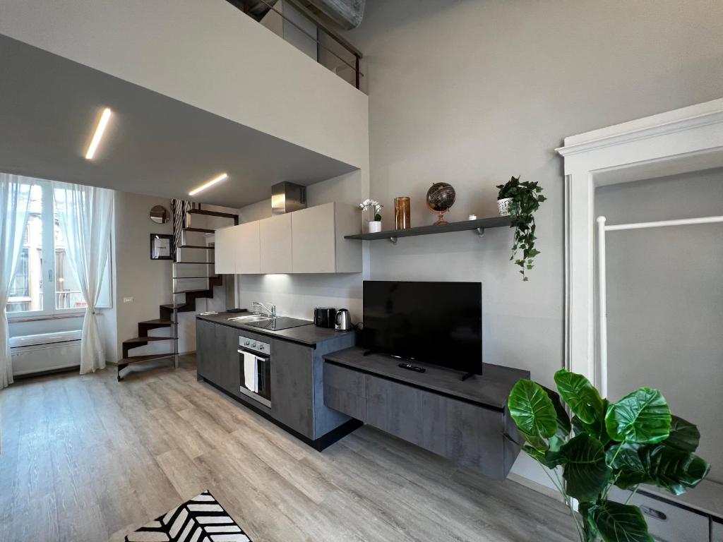 a living room with a kitchen with a flat screen tv at KAMI-central beautiful apartment over the roofs in Siena