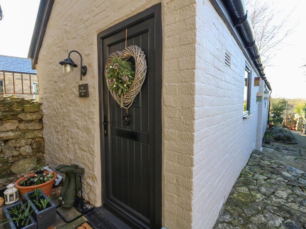 uma porta preta com uma coroa de flores no coração em The Kiln House em Weymouth