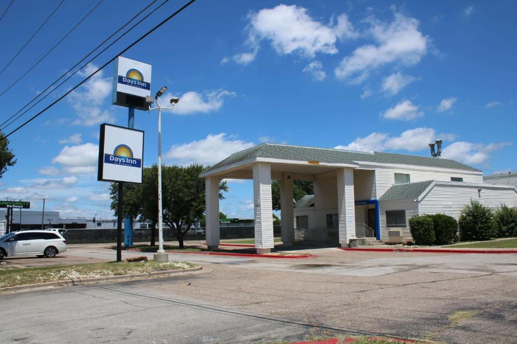 um posto de gasolina com um sinal em frente em Days Inn by Wyndham Waco University Area em Waco