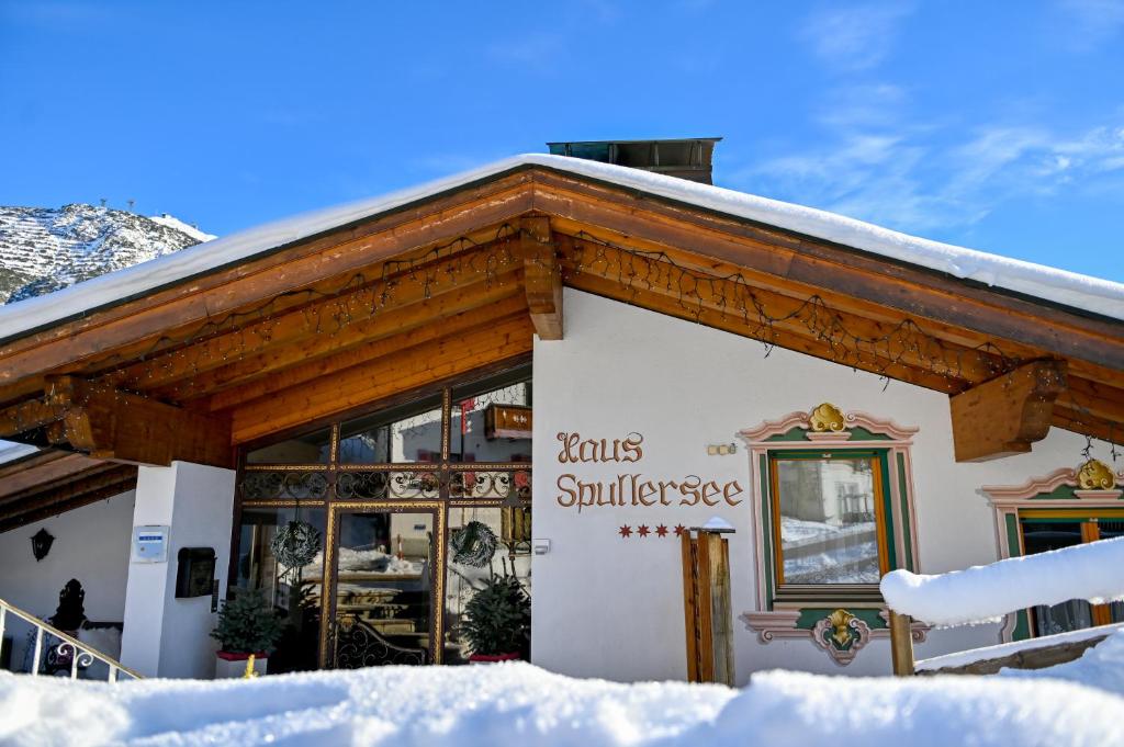 un bâtiment avec un toit recouvert de neige dans l'établissement Appartements Spullersee, à Lech am Arlberg