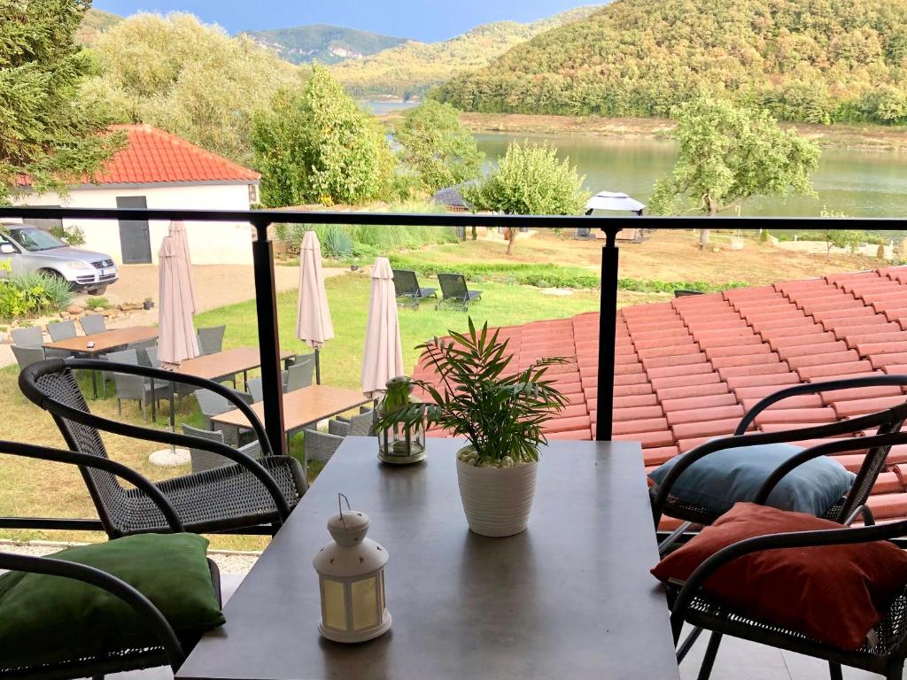 a table on a balcony with a view of a lake at Drive Point (Adventure Lake Resort) in Asparukhovo