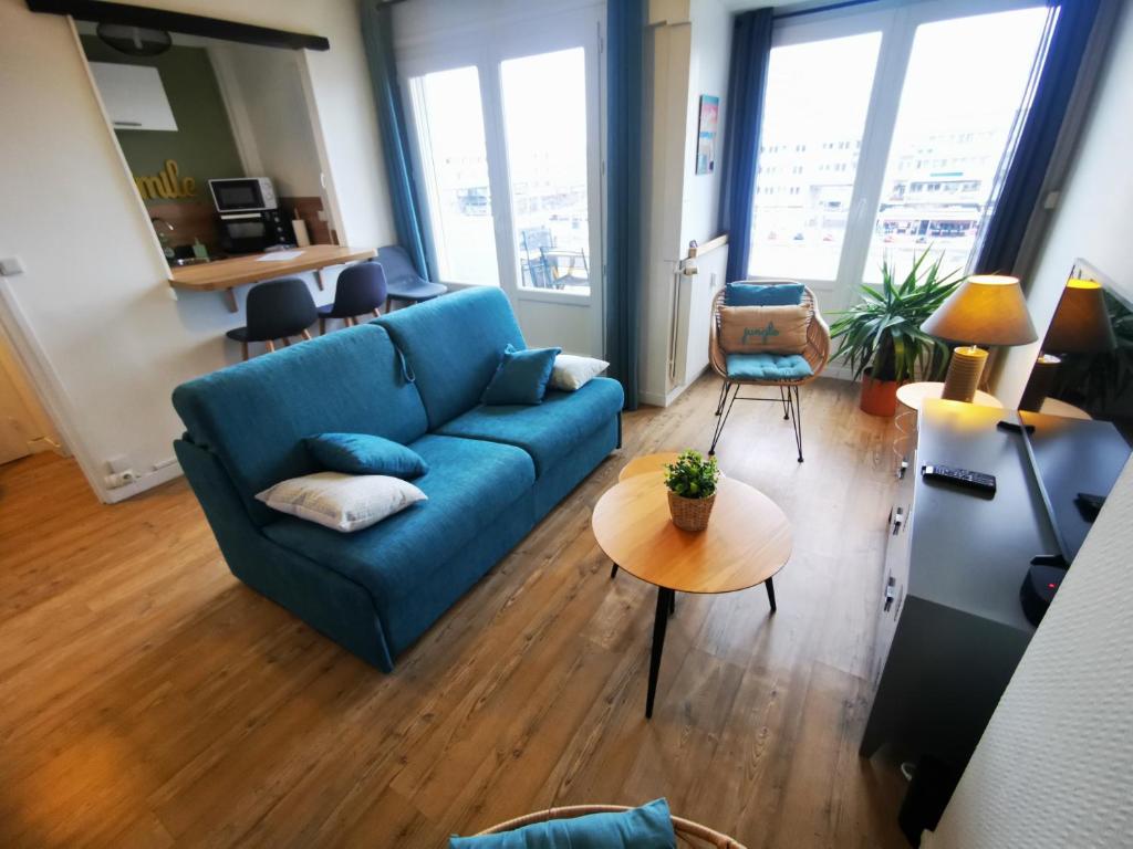 a living room with a blue couch and a table at Le Smile in Calais